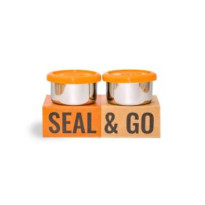 Boxed set of 2 stainless steel pots with orange silicone lids, designed for storing salad dressings or small snacks.